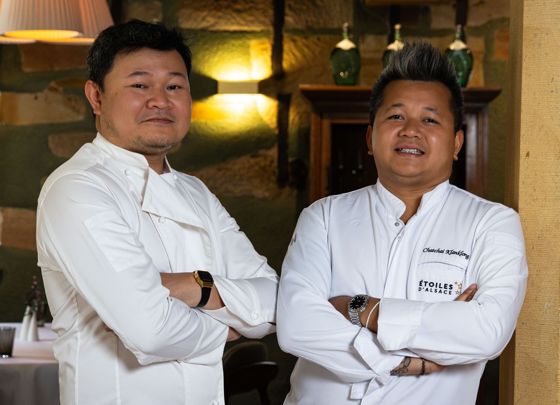 Deux cuisiniers en veste blanche les bras croisés dans la salle du Restaurant l'Orchidée