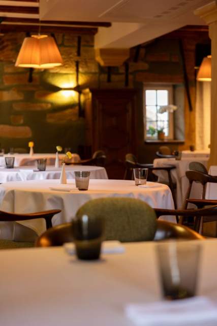 Salle de restaurant avec tables rondes en nappes blanches et éclairage tamisé, Hôtel l'Orchidée