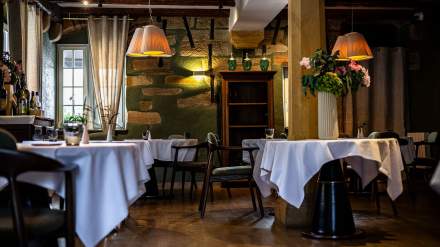 Salle de restaurant aux murs verts avec tables dressées et luminaires cuivrés, Restaurant l'Orchidée