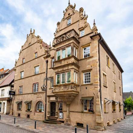 Façade Renaissance de l'Hôtel l'Orchidée à Ensisheim, pignon sculpté et balcon en pierre