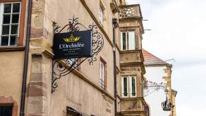 Enseigne en fer forgé "L'Orchidée Hôtel Restaurant 4 étoiles" fixée sur la façade en grès, Ensisheim Haut-Rhin